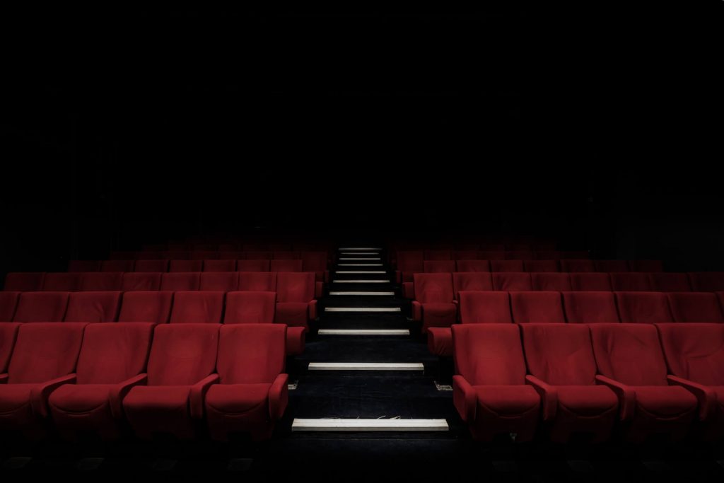Ein Bild eines gut ausgestatteten Kinosaals mit bequemen Sitzgelegenheiten, die ein Kinoerlebnis bieten.