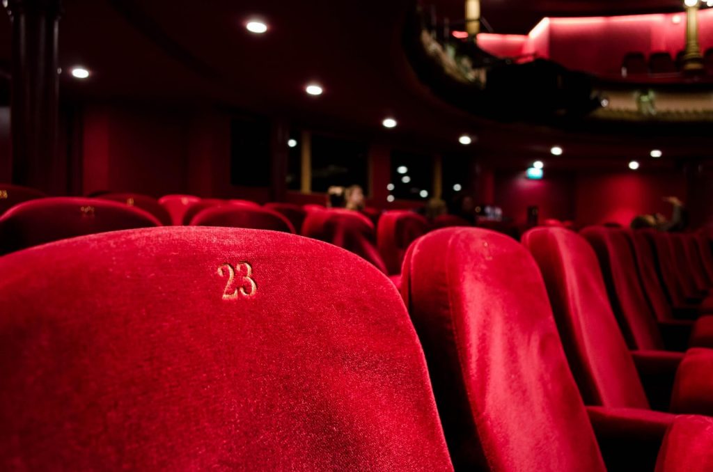 Eine Detailaufnahme von Kinosesseln, die den Betrachter dazu einlädt, sich den Komfort eines Kinos vorzustellen.