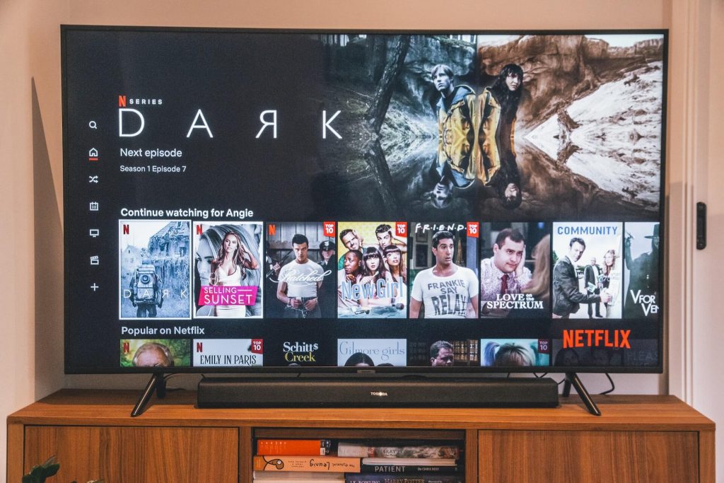 Ein Fernsehbildschirm zeigt die Netflix-App mit einer Auswahl an Original-Serien und -Filmen.